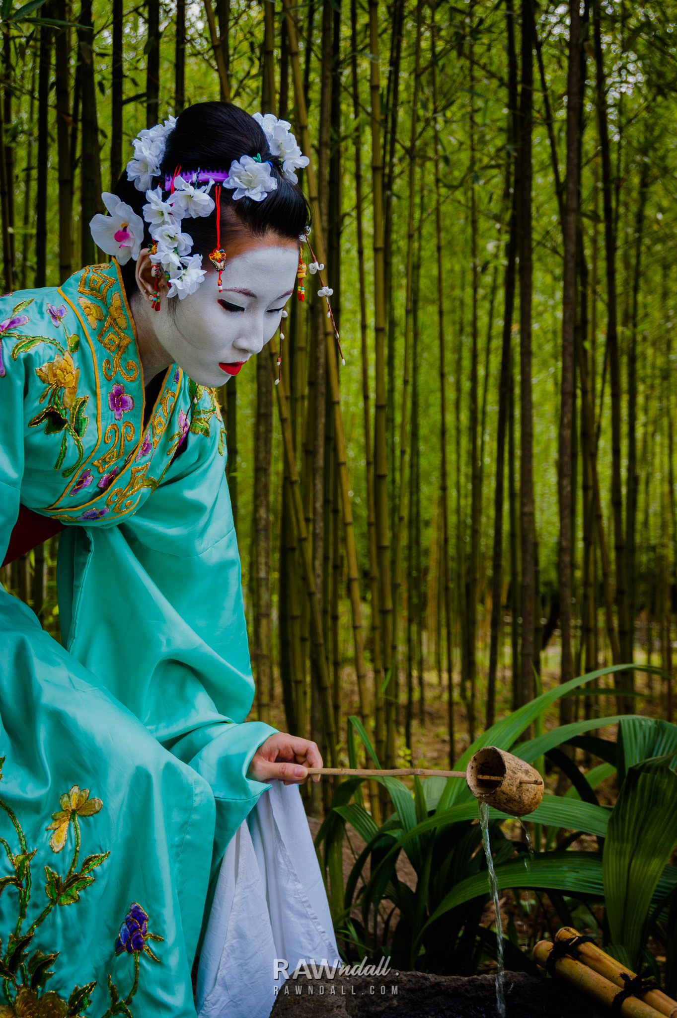 Mujer con traje de geisha entre bosque de bambú.
