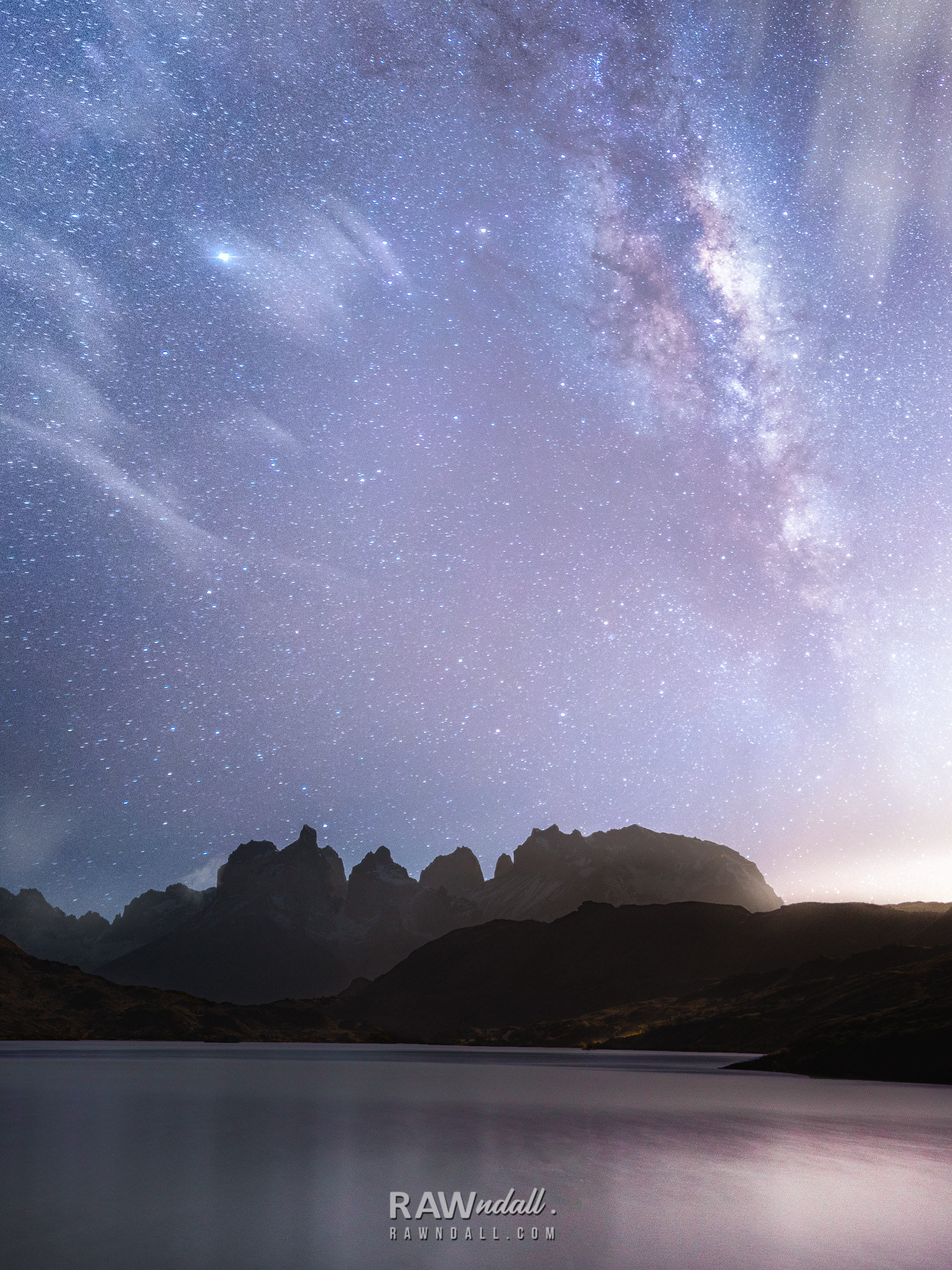 Vía láctea en un pasaje nocturno en Torres del Paine al frente de un lago.